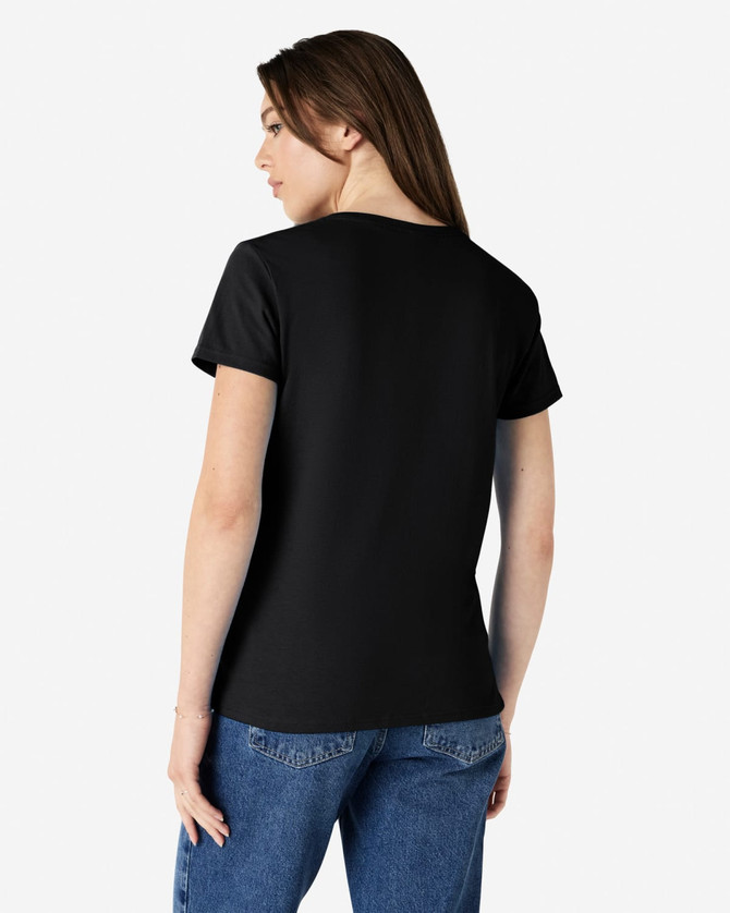 A black Gildan Heavy Cotton Ladies' T-Shirt is displayed from the back, worn with blue jeans. The shirt has a logo.