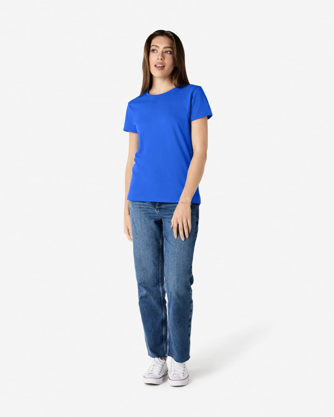 A blue Gildan Heavy Cotton Ladies' T-Shirt displayed on a model, paired with denim jeans and white sneakers.