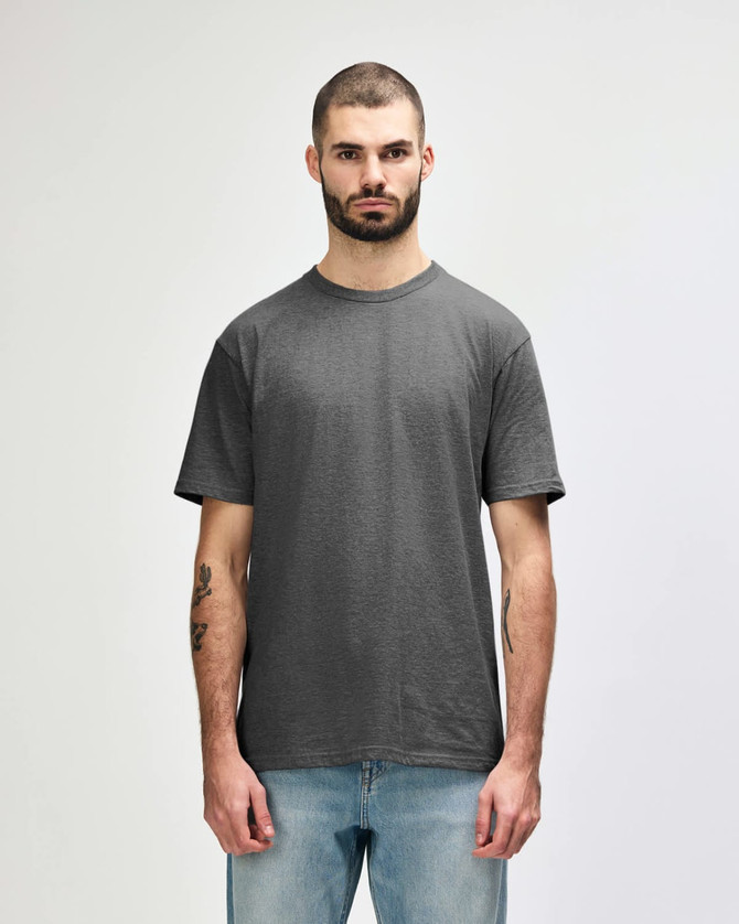 A grey Gildan Softstyle adult midweight T-shirt displayed on a male model, featuring a simple design and a logo.