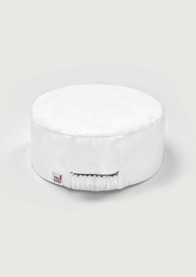A white chef cap with a round shape and an elastic band at the back. It features a small logo tag.