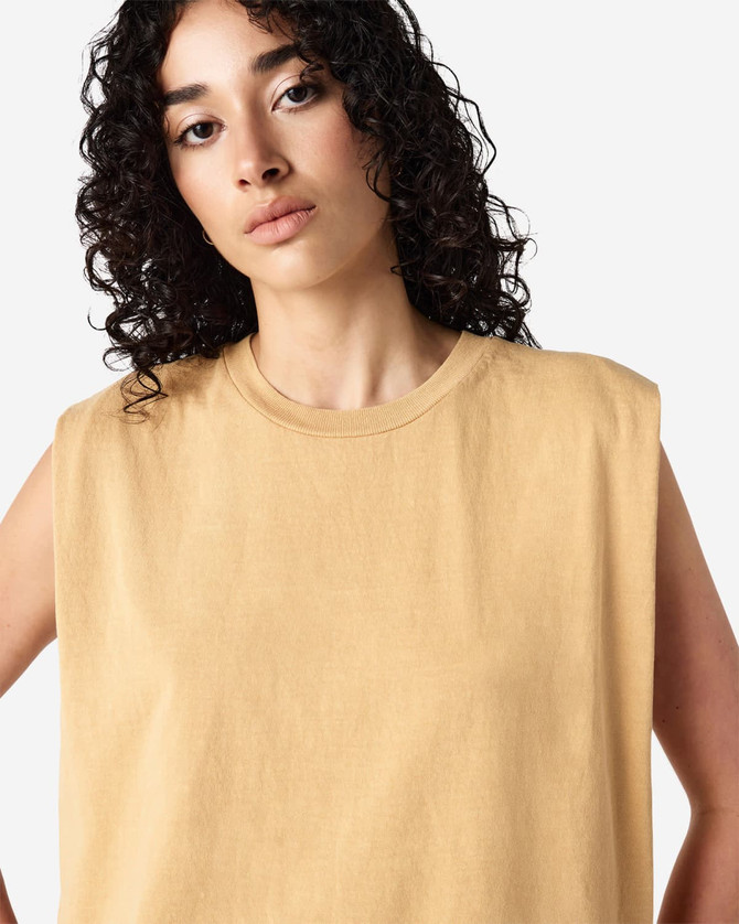 A muscle t-shirt in a soft yellow hue, featuring a crew neck and wide armholes. The shirt has a logo on it.