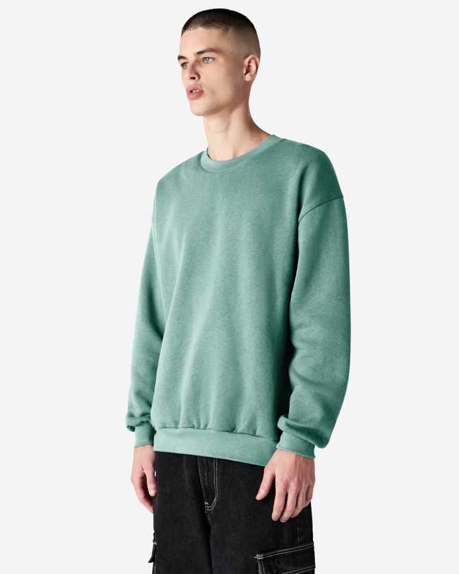A unisex crewneck sweatshirt in a soft green colour, featuring a relaxed fit and ribbed cuffs. It has a logo.