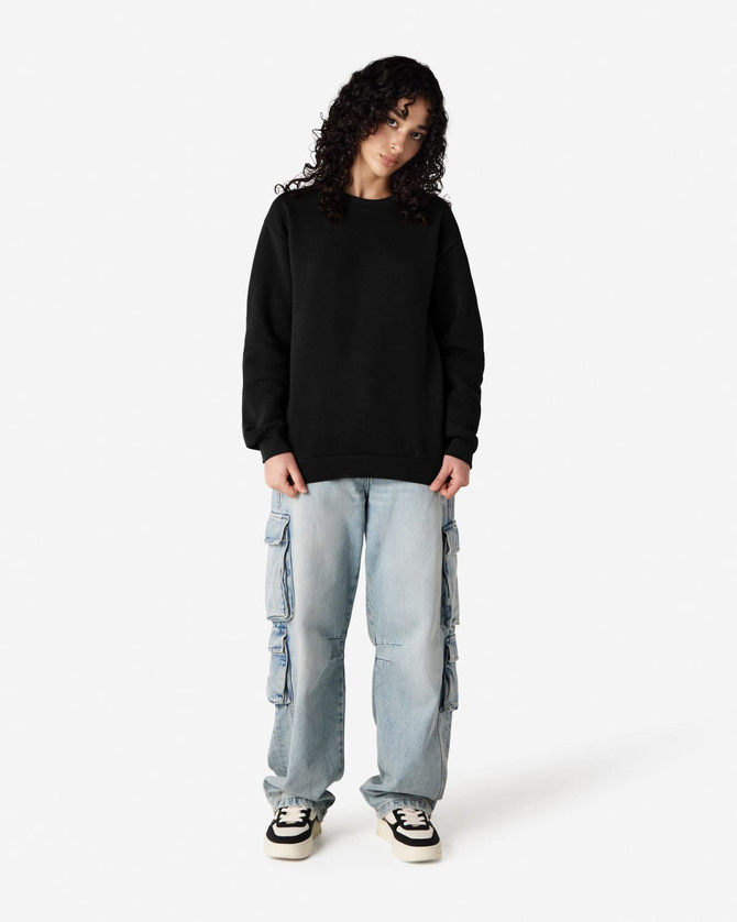 A unisex crewneck sweatshirt in black, paired with light blue cargo pants, featuring curly hair. The sweatshirt has a logo.