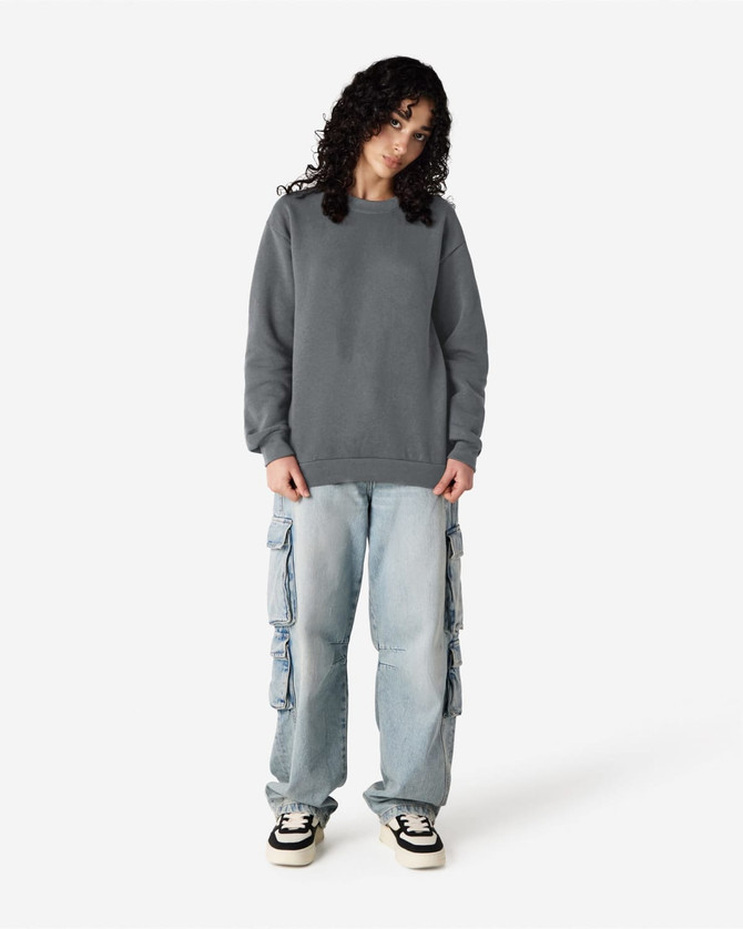 A grey unisex crewneck sweatshirt worn with light blue cargo pants and black shoes. The sweatshirt has a logo.