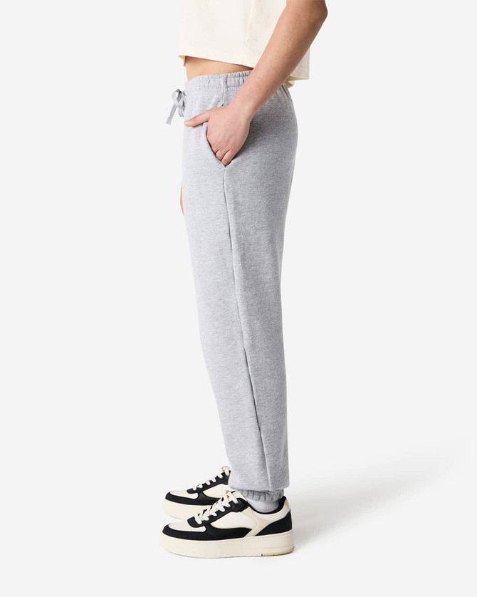 Grey unisex sweatpants made of fleece, featuring a drawstring waist and side pockets. Styled with sneakers.