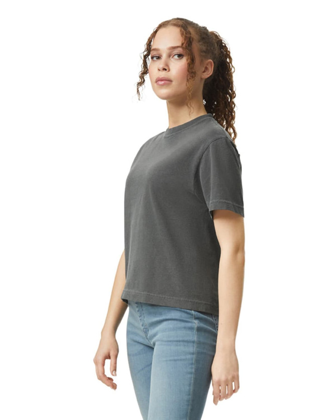 A boxy women's t-shirt in charcoal grey, featuring a logo on the front, styled with jeans.