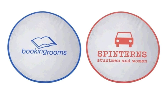 A round sunshade featuring a blue logo of an open book on one side and red text with a car graphic on the other.