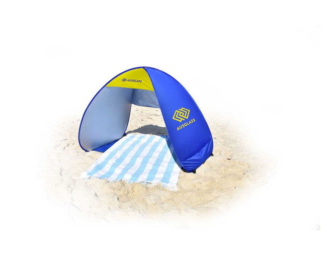 A blue and grey pop-up beach shelter with a striped towel on sand, featuring a logo on one side.
