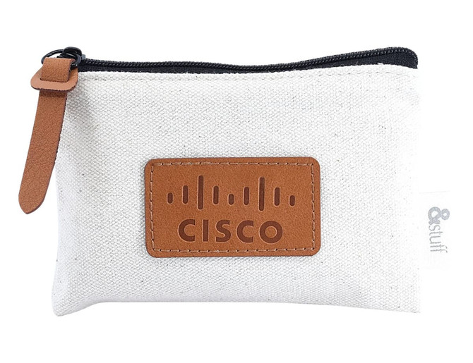 A cream pouch with a brown leather patch and logo, featuring a zip closure and a leather pull tab.