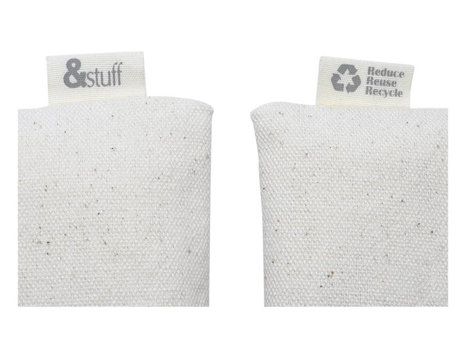 A pair of off-white fabric pouches with tags, featuring a logo and recycling message.
