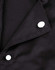 A close-up of a black chef jacket featuring two white exchangeable buttons on the collar.