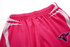 Pink volleyball shorts featuring a white design and a logo on the front.