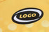 A close-up of a yellow sports jersey featuring a logo and patterned design.