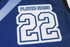 A blue sports jersey featuring the number 22 and a badge for player name, with a contrasting design element.