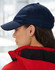 A navy athletic mesh cap is displayed, featuring a rounded peak and an adjustable strap at the back.