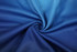 A swirling fabric with a gradient of blue shades, suitable for sports uniforms and jerseys. It has a textured pattern.