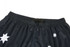 Black sports shorts featuring white star patterns and an elastic waistband. Includes a logo or branding element.