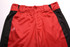 Red and black sports pants with a logo, featuring a button and two belt loops at the waist.