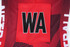A red netball dress featuring a large black "WA" patch and a geometric design on the fabric.