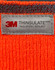 An orange Thinsulated cuff beanie with a grey label featuring branding and care information.