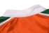 A rugby tee in orange with white and green accents at the collar. It features a logo on the side.