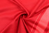 A red fabric swirled in a circular pattern, showcasing a smooth texture and slight sheen.