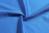 A blue fabric with a smooth texture, gathered in the centre, showcasing its soft and vibrant surface.