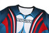 A rugby uniform top in blue, red, and white with a stylised design and a logo on the front.