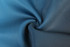 A close-up of blue fabric showing a smooth, textured surface, ideal for rugby uniform shorts.