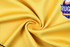 A smooth, yellow fabric with a logo in the corner, showing a spiral pattern.