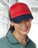 A red and navy Contrast Trucker Cap is worn by a woman with a smile, set in a bright indoor environment.