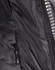 A close-up of a heavy quilted black puffer jacket featuring a zip and a side pocket. It has a logo on the front.
