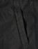 A close-up of a black fabric featuring a stitched pocket on a jacket. The material appears durable and textured.