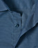 A close-up of a navy blue men's button-up shirt featuring a pin dot pattern and blue buttons.