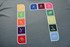 A grey fabric featuring a series of colourful icons representing various sports and activities, arranged in a rectangular design.