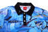 A blue fishing-themed polo shirt featuring various fish designs and a black collar, with a logo on the front.