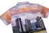A polo shirt featuring a vibrant skyline print with warm hues of orange and purple, and a logo on the back.