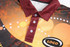 A customised Aboriginal polo featuring a vibrant design with shades of orange and maroon, and a logo on the side.