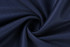 A fabric swatch in deep navy, featuring a textured pattern with a smooth, swirl design. It has a logo visible.