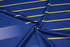 A blue and yellow striped fabric featuring a smooth mesh texture and a subtle sheen. It has a logo in one corner.