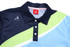 A polo shirt in blue, green, and navy with a branded logo on the chest and a button-up collar.