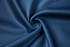 A textured, navy blue fabric displayed in a swirling pattern, highlighting its smooth surface.