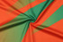 A fabric featuring bold orange and green stripes, with a smooth texture. The material has a slight sheen.