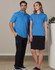 A man and woman standing together, wearing matching blue polo shirts. The man pairs his top with black cargo pants, while the woman wears a black skirt.
