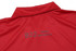 A red polo shirt with a collar and a textured mini waffle pattern on the fabric. It has branding on the back.