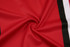 A fabric swatch featuring a smooth, red material with black and white stripes. It has a textured finish.