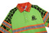 A green polo shirt with orange accents and reflective tape, featuring a logo on the front.
