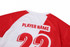 A red and white volleyball uniform featuring short sleeves and a number on the back. It includes a logo.