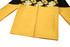 A yellow and black t-shirt jersey with floral patterns and two side pockets, featuring a logo.
