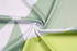 A fabric featuring bold patterns in green and white, showcasing a breathable mesh texture.